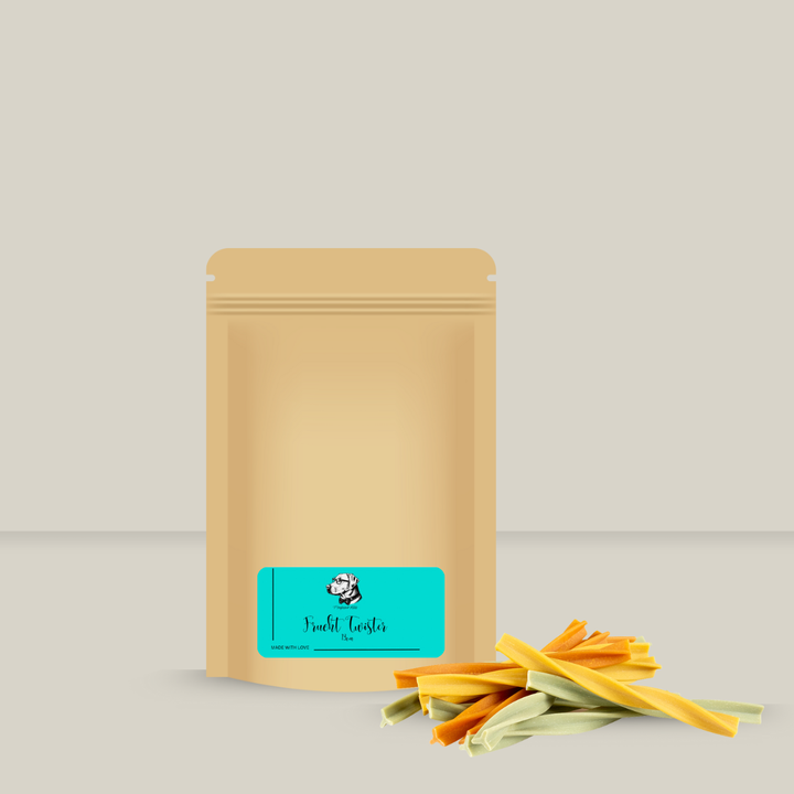 Papiertüte von Professor Keks gefüllt mit vegetarischen Kaustangen in gelb, orange und grün für Hunde auf hellem Hintergrund